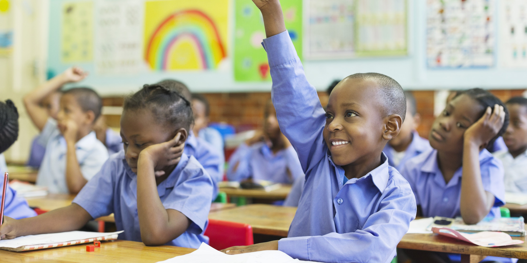 Primary school learner raising hand in class