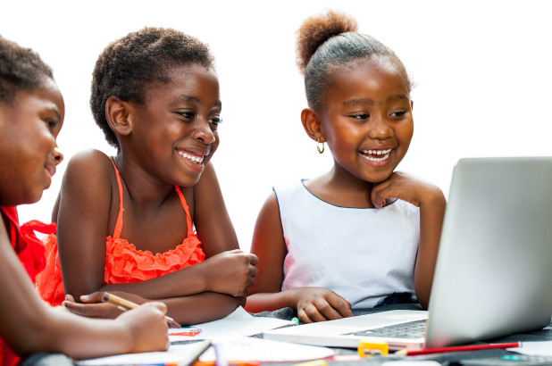 Young learners smiling at a laptop during study time